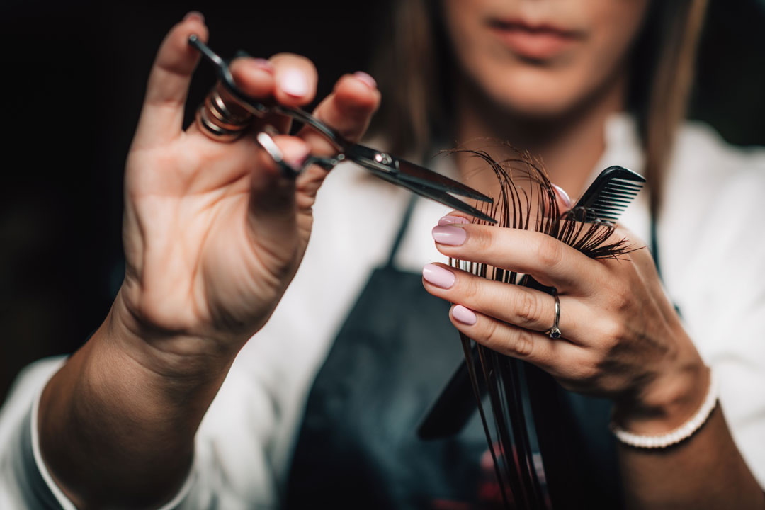 A background image of a person getting a hair trim by hair care professionals like Lemon Tree.