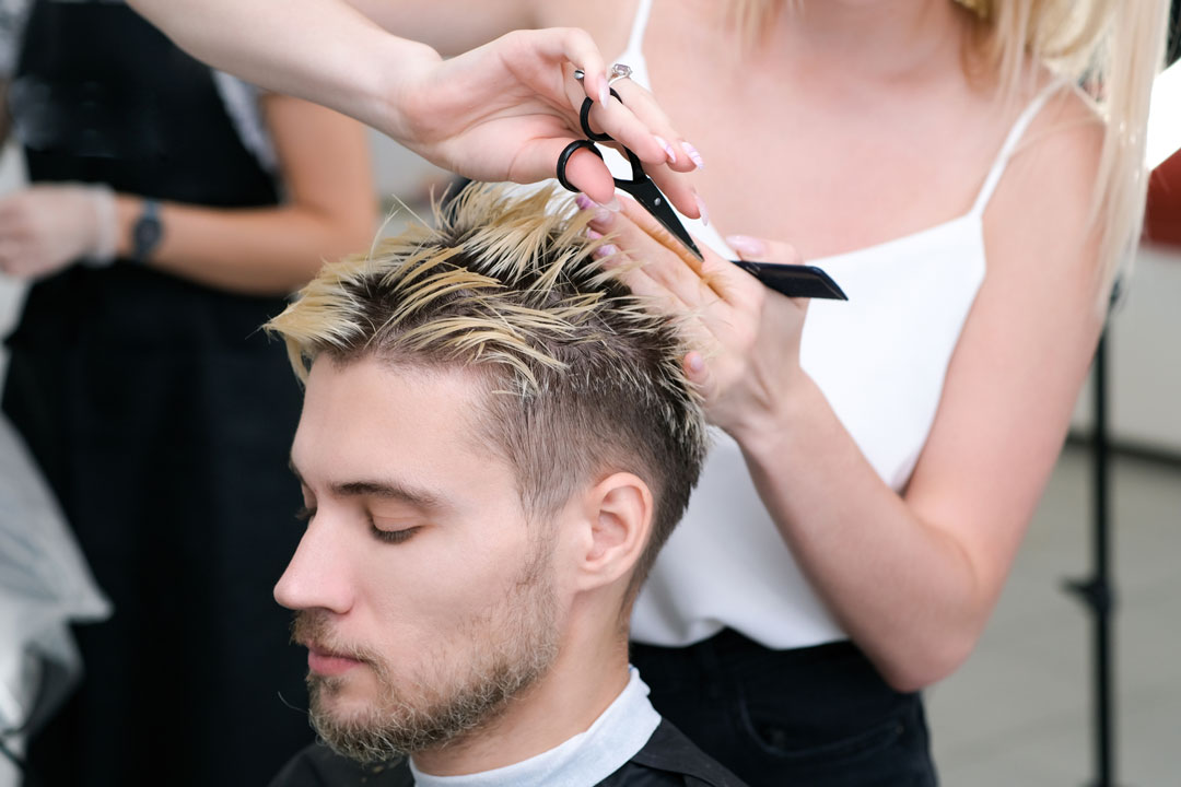 A background image of a man getting a haircut from professionals like Lemon Tree.