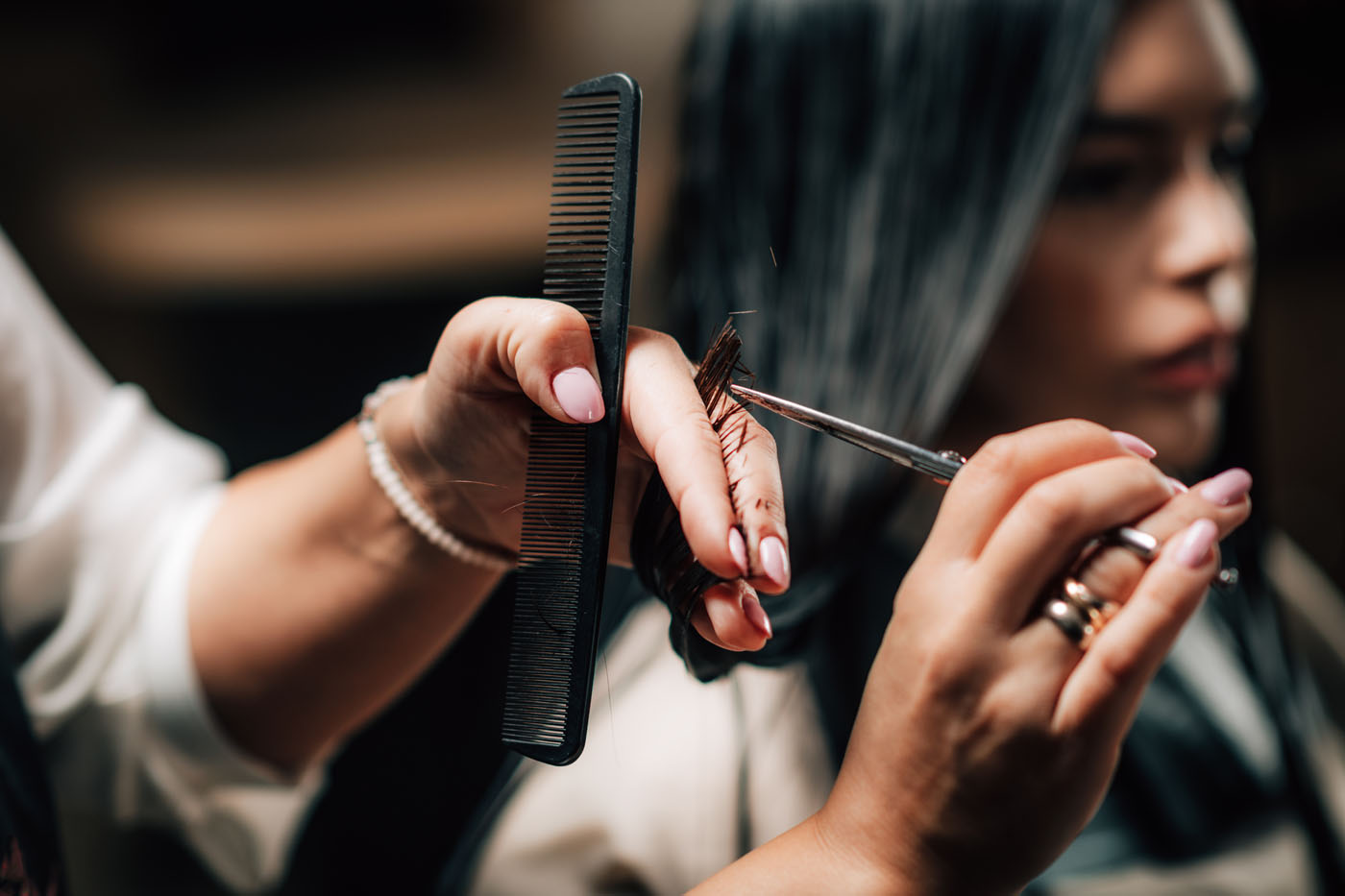 A person cutting hair in their salon franchise.
