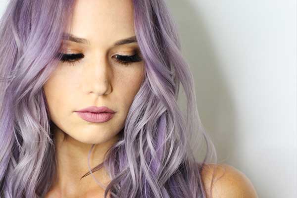 Woman with purple hair enjoying her fresh curtain bangs from Lemon Tree Hair Salons's services.